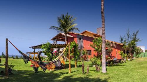 a house with a hammock in front of it at Vila icarai in Caucaia