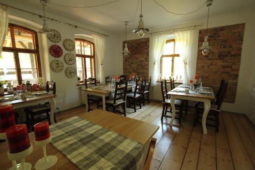 un comedor con mesas, sillas y ventanas en BORSZÓWKA Dom Nad Potokiem - Pensjonat, en Szklarska Poręba