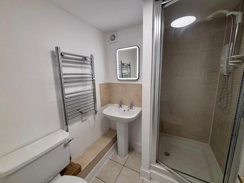 a white bathroom with a sink and a shower at Haymarket Hostel in Edinburgh