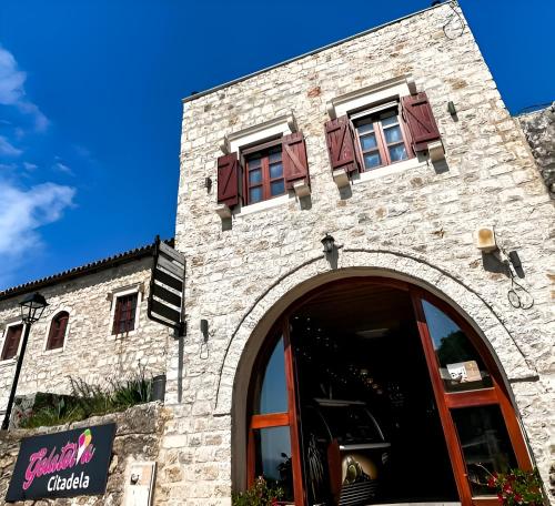un edificio in mattoni con finestre sopra di Citadela Old Town - Gelateria a Ulcinj