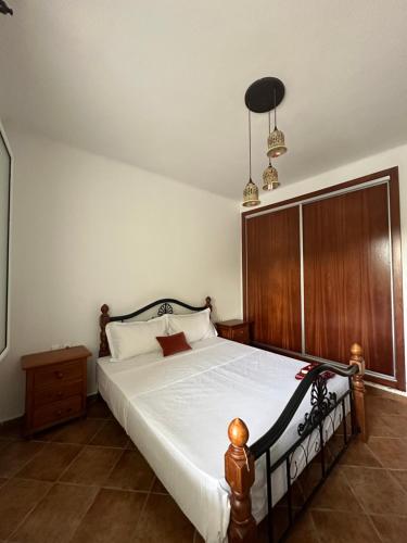 a bedroom with a large bed with a wooden headboard at Appartement in Tetouan