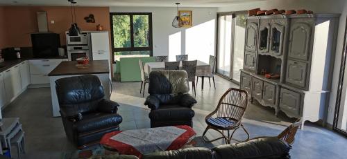 Il comprend une cuisine et un salon avec des chaises et une table. dans l'établissement Mas du Petit Pradal, à Cassagnas