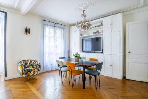 ein Esszimmer mit einem Tisch und Stühlen sowie einem TV in der Unterkunft Cozy one bedroom Appartement 16 ème Paris - Trocadéro in Paris