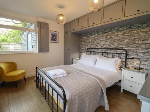 um quarto com uma cama e uma parede de tijolos em Pengeulan em Machynlleth