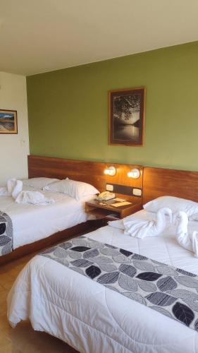 2 letti in una camera con pareti verdi di Park Hotel Mérida a Mérida