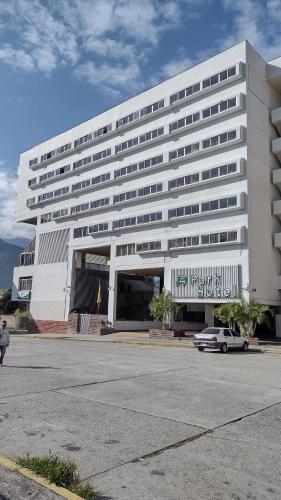 ein weißes Gebäude mit einem davor geparkt in der Unterkunft Park Hotel Mérida in Mérida