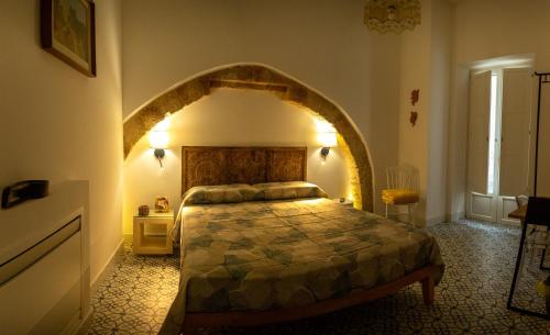 a bedroom with a large bed with an archway at La Terrazza Nel Borgo B&B in Copertino