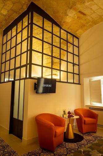 a lobby with two chairs and a tv on a wall at La Terrazza Nel Borgo B&B in Copertino