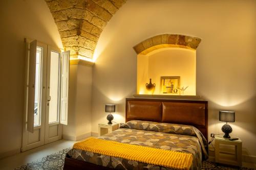 a bedroom with a bed and a large window at La Terrazza Nel Borgo B&B in Copertino