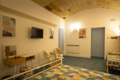 um quarto com uma cama e uma televisão na parede em La Terrazza Nel Borgo B&B em Copertino