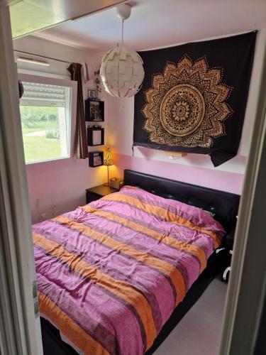 une chambre avec un lit avec une couette violette dans l'établissement villa avec jardin et piscine, à Vic-la-Gardiole