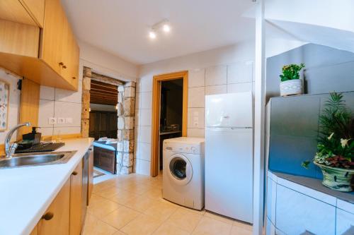 a kitchen with a white refrigerator and a washing machine at Infinity Residence - Charming Retreat in Kos in Kos Town