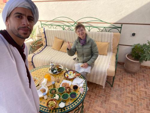 a man and a woman standing next to a table with food at Dar Mgouna Roses in Kalaat MGouna