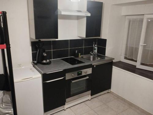 une petite cuisine avec un évier et une cuisinière dans l'établissement Studio centre ville Foix, à Foix