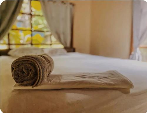 a rolled up towel on a bed with a window at Kinkajoungalows - Amaya Family, Drake Bay, Osa Peninsula in San Pedrillo