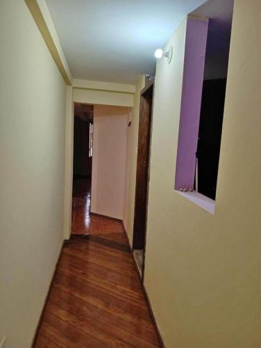 un pasillo vacío de un apartamento con suelo de madera en Rio habitaciones en Riobamba