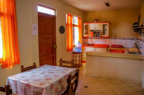 cocina con mesa y cocina con cortinas de color naranja en Hospedaje Guadalupe Inn, en Máncora
