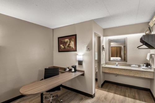 a hotel room with a desk and a sink at Red Roof Inn Enfield in Enfield