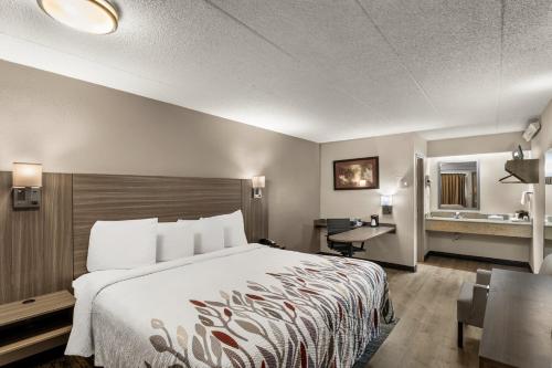 ein Hotelzimmer mit einem Bett und einem Schreibtisch in der Unterkunft Red Roof Inn Enfield in Enfield