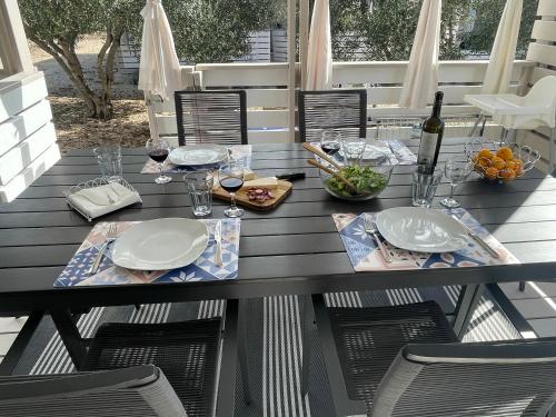 a table with plates and wine glasses on a deck at Marty House Drage in Drage