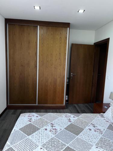 a bedroom with a bed and wooden cabinets at Casa Alexandre 7 in Monte