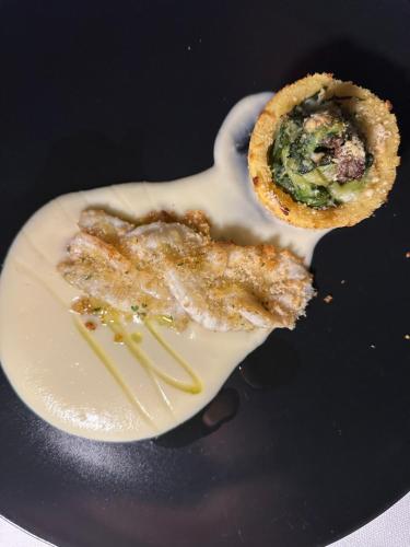 a plate with a piece of food on a spoon at Hotel Sinuessa Terme in Mondragone