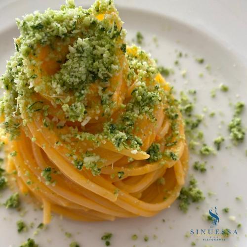 a plate of pasta with pesto and cheese on it at Hotel Sinuessa Terme in Mondragone