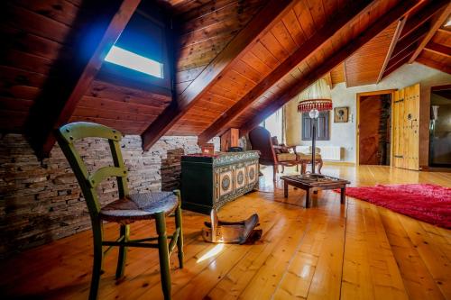 a living room with a stone wall and wooden ceilings at Vila Voula in Aristi