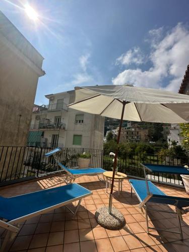 a patio with two chairs and an umbrella at Villa Girasole Luxury Amalfi Coast in Minori