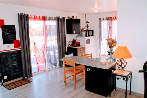 une cuisine avec une table et des chaises dans une pièce dans l'établissement Le 16 BIS Appart Climatisé PMR, à Vouneuil-sous-Biard