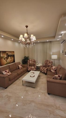 a large living room with couches and a chandelier at Western Gate Residence 1 - Amman, Jordan in Amman