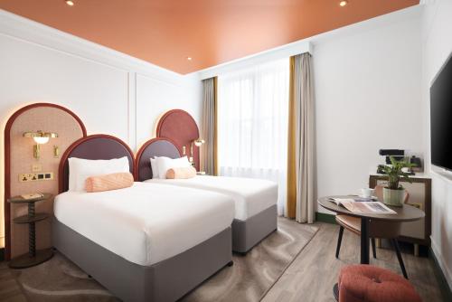 Habitación de hotel con 2 camas y TV en Holiday Inn London Oxford Circus, an IHG Hotel en Londres