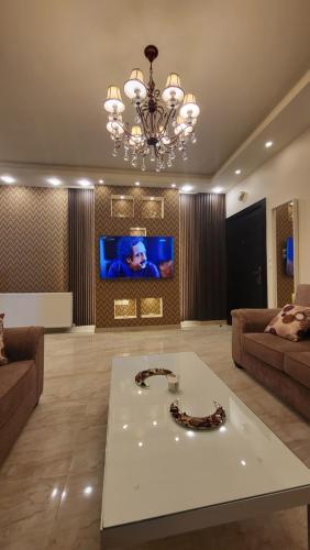 a large living room with a chandelier and a table at Western Gate Residence 1 - Amman, Jordan in Amman
