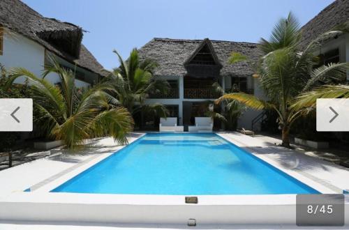 a swimming pool in front of a house at Ayras Hotel Zanzibar in Paje