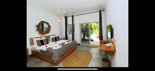 a bedroom with a bed and a mirror and a table at Ayras Hotel Zanzibar in Paje
