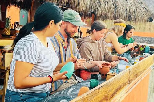 a group of people sitting around a counter looking at their cell phones at Casa Pepe in Sayulita