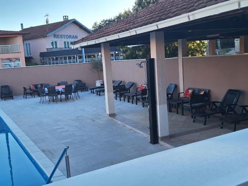 a patio with chairs and tables next to a building at Juka in Međugorje