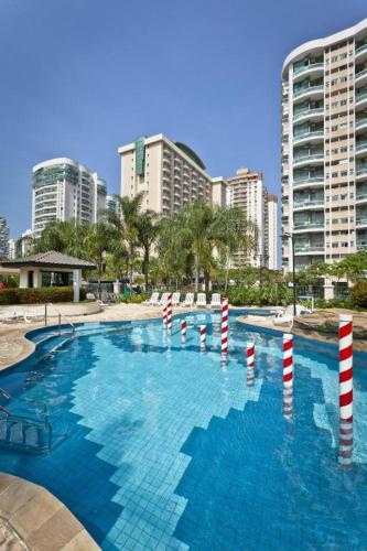 a swimming pool with red and white poles in a city at Conforto no Coração da Barra in Rio de Janeiro