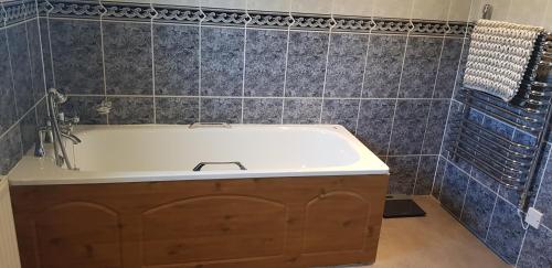 a bath tub in a bathroom with blue tiles at No 7 in Back