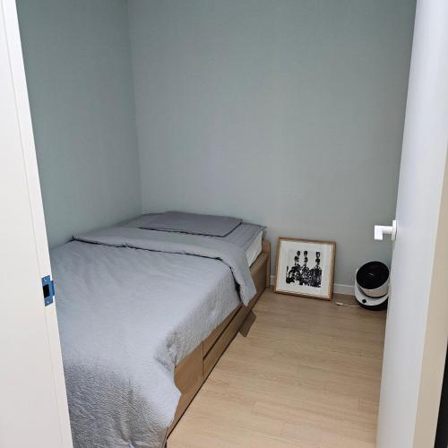 una piccola camera con letto e quadro di Caty House Hyeopjae a Jeju