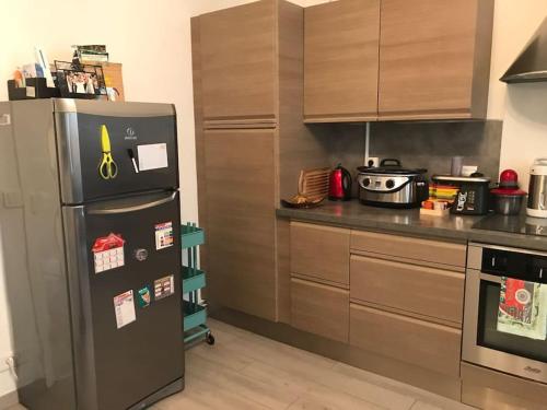 Il comprend une cuisine équipée d'un réfrigérateur et d'une cuisinière. dans l'établissement Appart 2 pièce 52 m2 vue jardin, à Paris