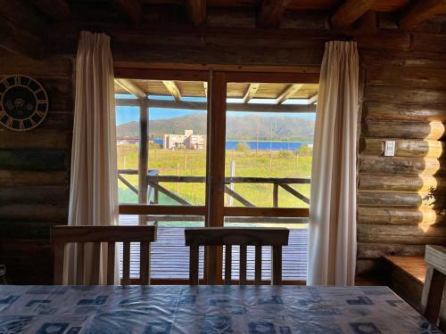 a room with a large window with a table and chairs at Cabaña La Maura in La Estancia