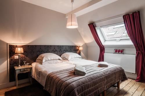 - une chambre avec un grand lit et une fenêtre dans l'établissement La Maison du Champlain - Chambres d'hôtes, à Lille
