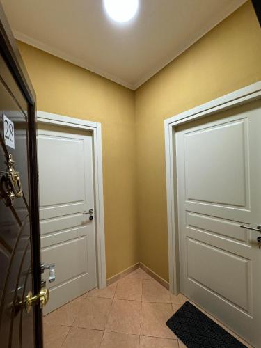 two doors in a room with yellow walls at Berat City Panorama 1 in Berat