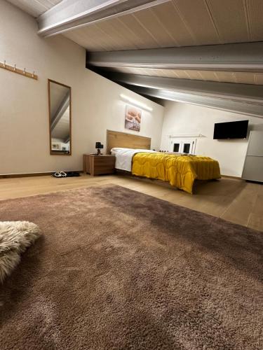 - une grande chambre avec un lit et une couverture jaune dans l'établissement Wild bed & breakfast, à Fiorano Modenese