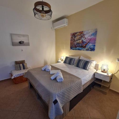 a bedroom with a large bed with towels on it at Omisu Apartments in Kithnos
