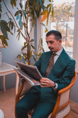 a man sitting in a chair reading a book at Hotel Sinuessa Terme in Mondragone