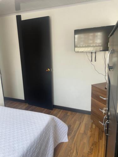 um quarto com uma cama e uma porta preta em The Lofts Urbanos Manizales em Manizales