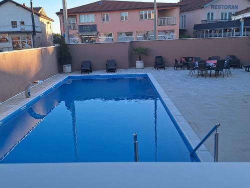 a large blue swimming pool with chairs and tables at Juka in Međugorje