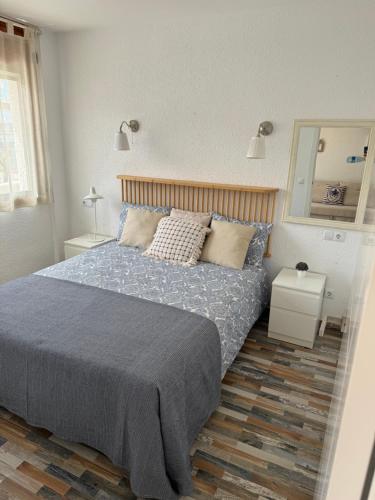 a bedroom with a bed and two tables and a mirror at La Marinada in Cambrils